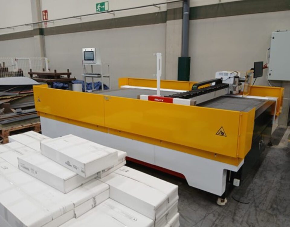 Cortadora CNC adaptada con protecciones laterales de chapa metálica pintadas en color amarillo.