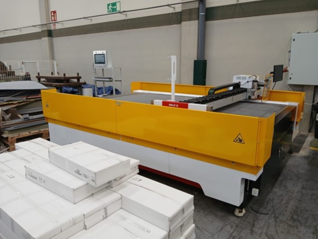 Cortadora CNC adaptada con protecciones laterales de chapa metálica pintadas en color amarillo.